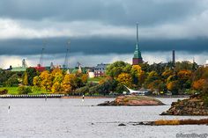 an image of the city from across the water with boats on it and clouds in the sky