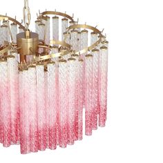 a pink and white chandelier hanging from a gold ceiling fixture with glass rods