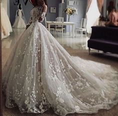 a woman in a wedding dress is looking into the mirror