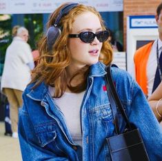 a woman wearing headphones and carrying a purse