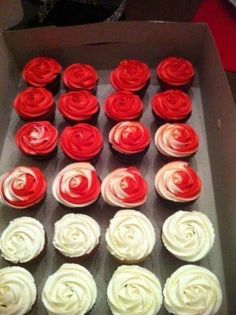 cupcakes with red and white frosting in a box on a table top