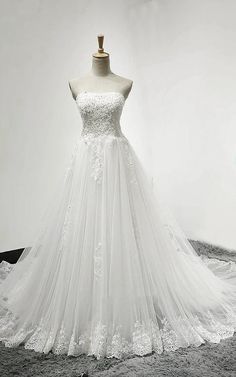 a white wedding dress on display in front of a mannequin