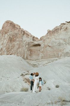 mom in cream dress camel western hat dad in cream shirt gray jeans young daughters in denim jackets white skirts in desert canyon at amangiri resort