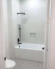 a bathroom with a toilet, bathtub and shower