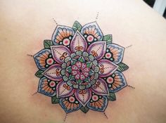 a woman's back with a colorful tattoo on it