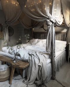 a bed with white sheets and lights hanging from it's canopy over the headboard