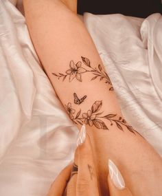 a woman's arm with flowers and butterflies on it