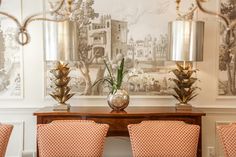 a dining room table with four chairs and two vases on it