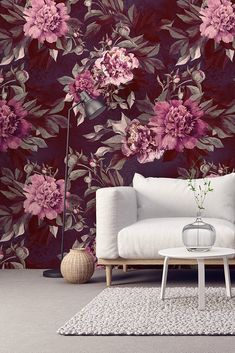 a living room with floral wallpaper and a white couch in front of the sofa