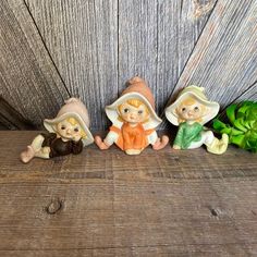 three little figurines sitting on top of a wooden table