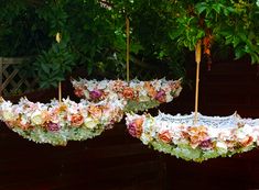 two umbrellas with flowers hanging from them