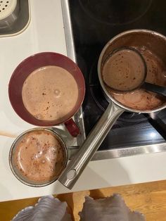 two saucepans filled with hot chocolate sitting on top of a stove