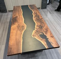 a wooden table with an interesting design on it's surface in the middle of a room