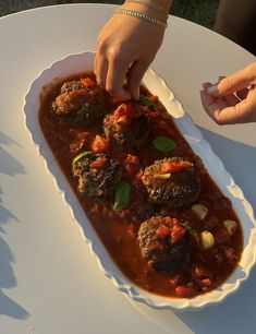 a white plate topped with meatballs covered in sauce