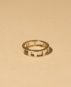 a gold ring with three baguets on it sitting on top of a table