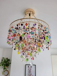 a chandelier hanging from the ceiling in a living room with pictures on the wall