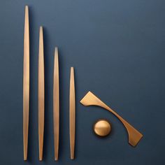 three different types of knives and spoons on a blue surface with gold colored handles