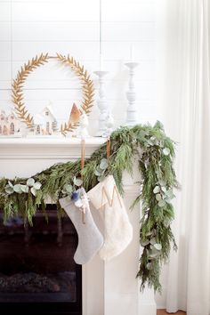 stockings hanging from a mantel decorated with greenery