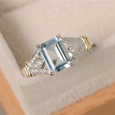 an aqua and white diamond ring in a box