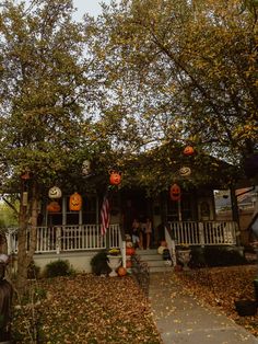 a house decorated for halloween with pumpkins on the porch