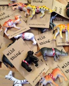 there are many small toy animals on the table with some cards that say wild things