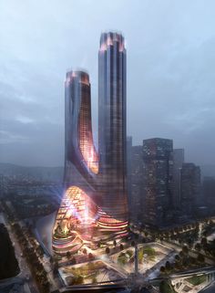 an aerial view of two tall buildings in the middle of a city at night time