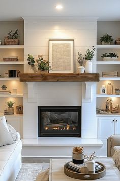 a living room filled with furniture and a fire place next to a white couch in front of a fireplace