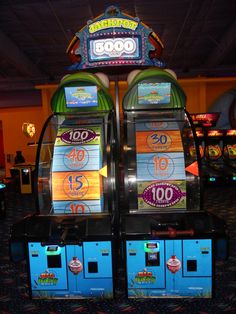 two slot machines sitting next to each other on top of a blue carpeted floor