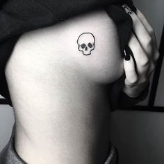 a woman's stomach with a skull tattoo on her lower back and right side