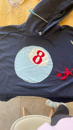 someone is using scissors to cut out the number eight on a hoodie