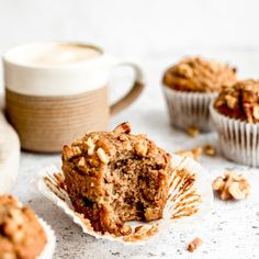 some muffins are sitting on a plate and next to a cup of coffee