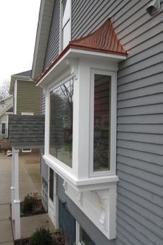 a house with a red roof and white trim on the side of it's windows