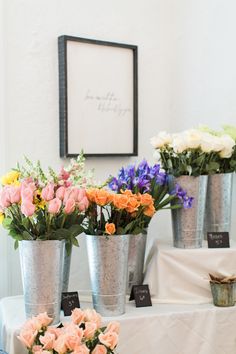 flowers are in buckets on a table