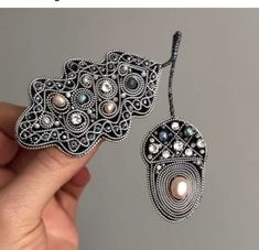 a pair of earrings is being held by someone's hand with the caption