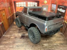 a toy truck is on display in a room with brick walls and wooden flooring