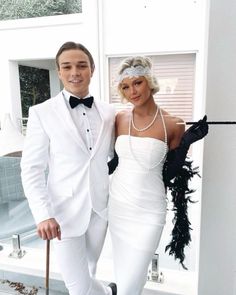 a man and woman dressed in white posing for the camera