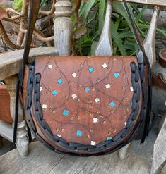 This is a beautiful vintage leather hippie boho shoulder bag...it has painted flowers on the flap and some real nice black lacing...the lacing is new and gives this bag some real rustic vibesthje leather was cleaned and oiled and conditionedthere are some minor cracks on the flap where the flap folds over but these are surface cracks and no reason to worry.... measurements are  8 inches tall, 10 inches across, gusset measures 3 inches wide and the shoulder strap drop is 16 1/2 inches Leather Bohemian Satchel For Festival, Bohemian Leather Saddle Bag, Bohemian Leather Satchel For Festivals, Bohemian Brown Saddle Bag With Adjustable Strap, Bohemian Crossbody Saddle Bag With Adjustable Strap, Bohemian Saddle Bag With Adjustable Crossbody Strap, Bohemian Saddle Bag With Adjustable Strap, Leather Satchel Saddle Bag For Festivals, Bohemian Hand Tooled Saddle Shoulder Bag