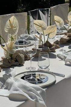 the table is set with white linens and place settings for two people to sit at