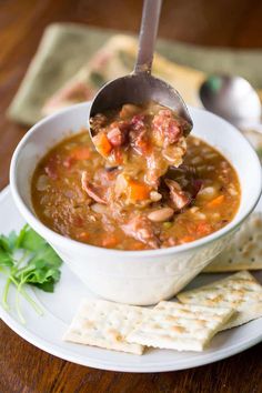 a white bowl filled with soup next to crackers