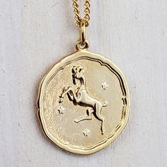 a gold coin with a horse on it sitting on a white surface, in front of a chain