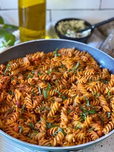 a pan filled with pasta and sauce on top of a table