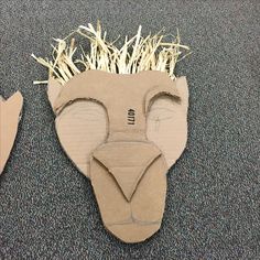 an animal mask made out of cardboard with grass growing from it's mouth and nose