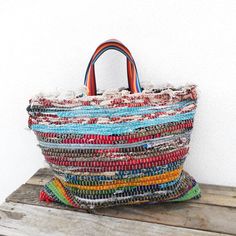 Hey friend! I want to tell you about this charming bag I've created. It's super versatile and sustainable because it's made from a jarapa with strips of recycled rags. Even though it's small, it has a surprising capacity for all your daily essentials. Its two short rainbow handles let you carry it comfortably on your arm or hand, adding a touch of joy to your style. Plus, it has a practical interior pocket designed for your cell phone, keeping it safe and accessible at all times. Each side of th Trendy Multicolor Hobo Tote Bag, Trendy Multicolor Hobo Bag Tote, Multicolor Shoulder Bag With Rolled Handles, Multicolor Bag With Double Rolled Handles, Multicolor Double Handle Bag With Rolled Handles, Casual Multicolor Hobo Tote Bag, Casual Multicolor Pouch Beach Bag, Multicolor Shoulder Bag With Rolled Handles For Shopping, Upcycled Shoulder Bag For Daily Use