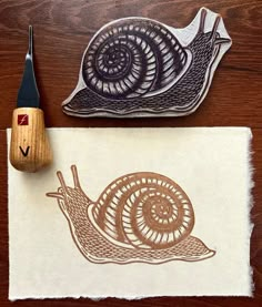 a rubber stamp with a snail on it next to a pair of scissors