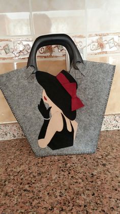 a handbag with an image of a woman wearing a hat and holding a purse