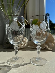 two wine glasses sitting on top of a table