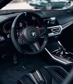 the interior of a bmw car with black leather and chrome trims, including steering wheel