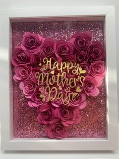 a mother's day card made out of pink paper flowers in a white frame