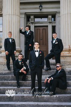 a group of men in tuxedos posing on steps