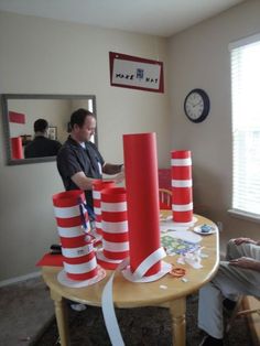 two men sitting at a table with red and white striped cones on top of it